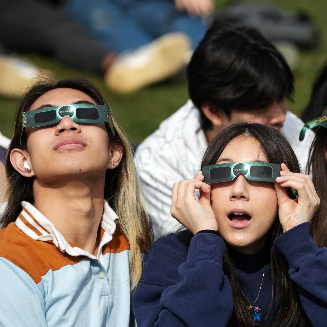 Two+students+watch+the+eclipse+through+鶹Ů-branded+glasses.